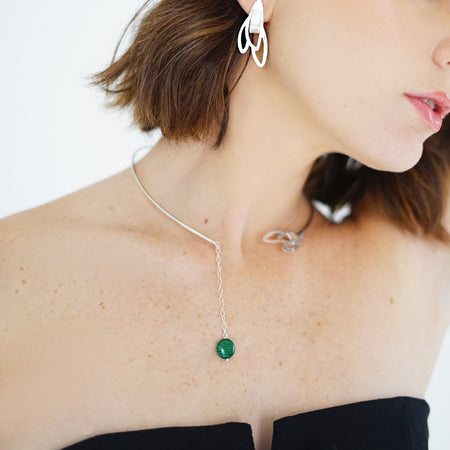 Handcrafted Vera Open Choker from the Seed Collection featuring a blooming seed design on one side and a vibrant malachite stone pendant on the other. Crafted in sterling silver, this necklace showcases a chic, elegant style suitable for any occasion.