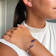 Load image into Gallery viewer, Woman wearing an Amethyst Cuff Bracelet crafted with natural amethyst stones and sterling silver, adding a refined touch of elegance.

