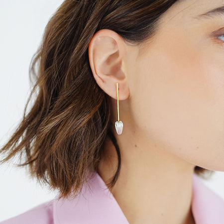 Seed Drop Earrings in Mixed Metal, featuring a sleek, seed-inspired design with a blend of sterling silver and 18k gold-plated accents. Elegant and bold, these earrings symbolize growth and renewal.