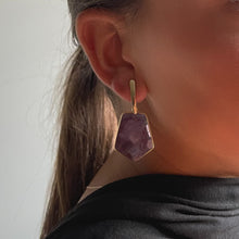 Load image into Gallery viewer, Woman wearing Éclat Amethyst Dangle Earrings featuring natural amethyst stones delicately sculpted and set in 18K gold-plated over sterling silver.
