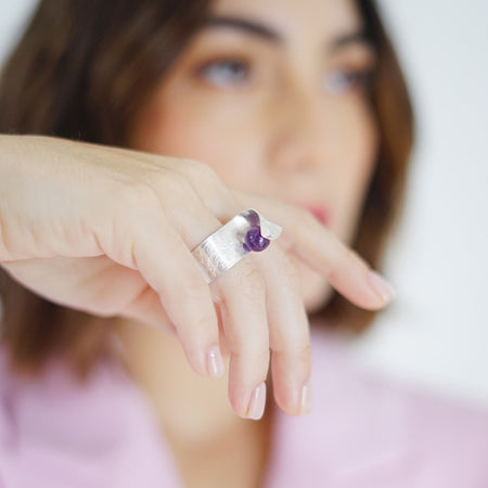 Handmade Maia Amethyst Ring featuring a radiant purple gemstone gracefully wrapped in sterling silver lines, creating a modern and sophisticated design.